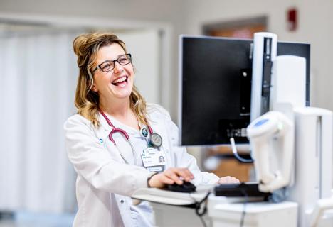 Nurse smiling at computer