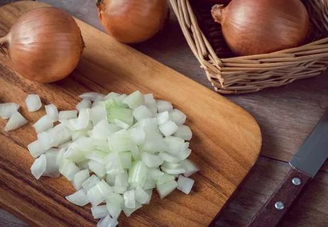 chopped and whole onions on cutting board