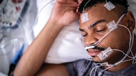 Man with polysomnography electrodes attached to his head