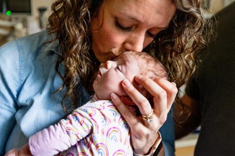Mother kissing newborn