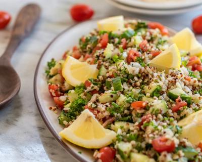 Bowl of gluten-free quinoa tabbouleh, with lemon wedges