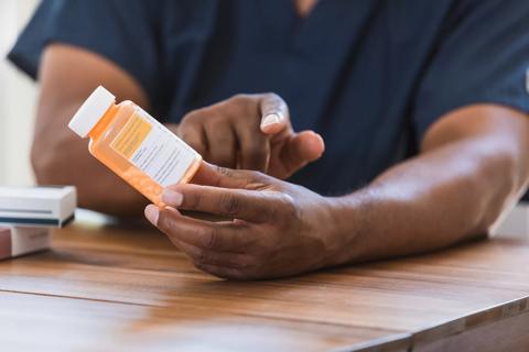 Healthcare provider holding bottle of prescription medication