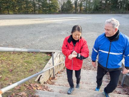 Older adults walking outside while checking step count on wrist device