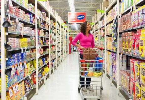 A person pushing a shopping cart in a grocery store.