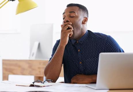 man tired and yawning at work