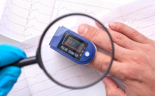 Magnifying glass over a pulse oximeter on a finger