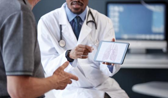 Healthcare provider showing lung anatomy on tablet to patient