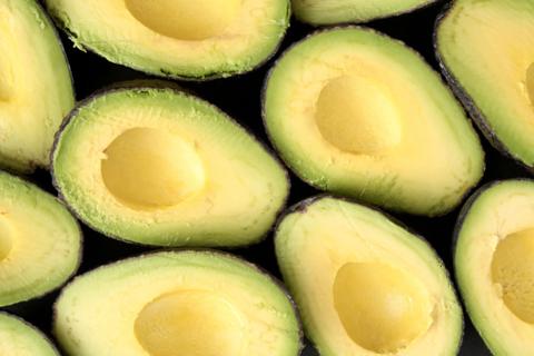 Many halved and pitted avocados