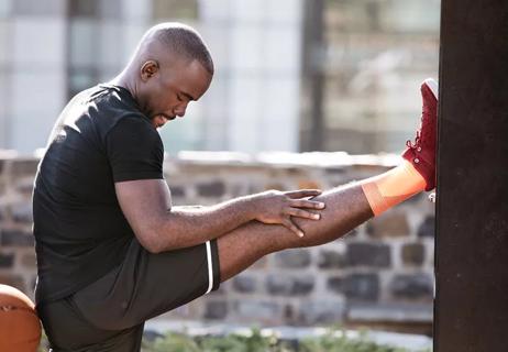 man stretching legs after exercising