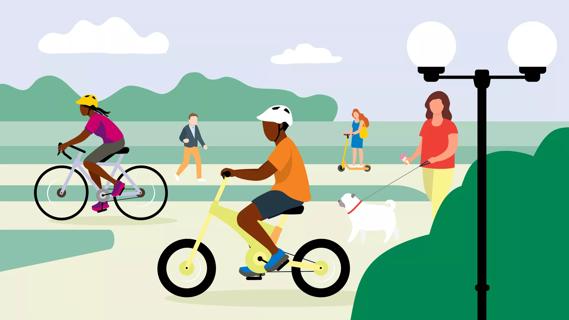 People biking, scootering and walking in a park