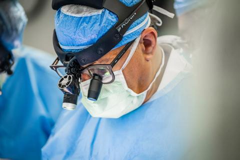 Dr. Najm in the operating room wearing surgical loupes