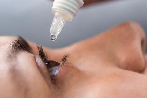 Close-up of face profile, with eye open and eye drops being added to the eye