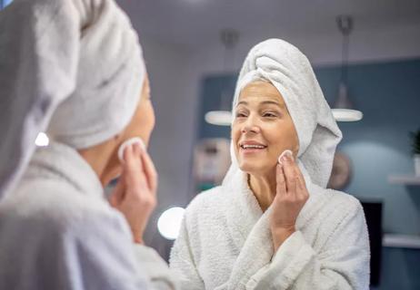 Person applying skin toner before putting on makeup and moisturizer.