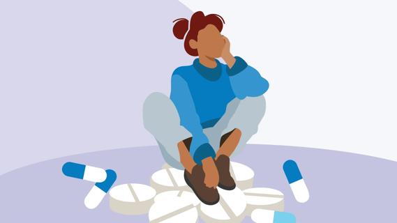Person with their chin resting on hand sitting on oversized pills and capsules