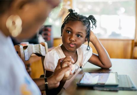 Child getting help with school work from adult