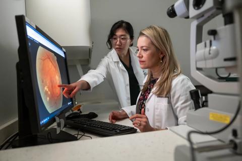 Dr. Rachitskaya and medical student Julia Joo studying an eye on a computer screen