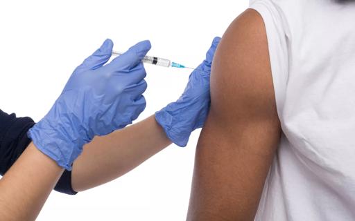 Hands in floves make vaccination ingection in shoulder, isolated