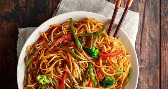 Bowl of Szechwan noodles with broccoli and red pepper, with chopsticks