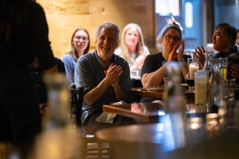 A person sitting a a bar smiling.