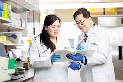 Researchers standing in lab looking at document