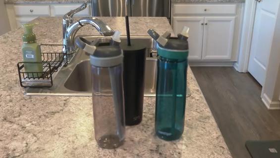 Reusable water bottles near sink.