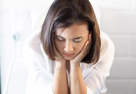 A woman looking upset in the bathroom.