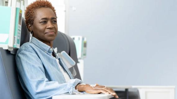 Woman sitting in a chair and receiving a drug infusion