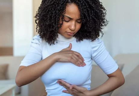 Woman performing breast exam on herself.