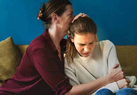 Mother holding depressed daughter