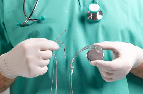 Surgeon holding a new pacemaker