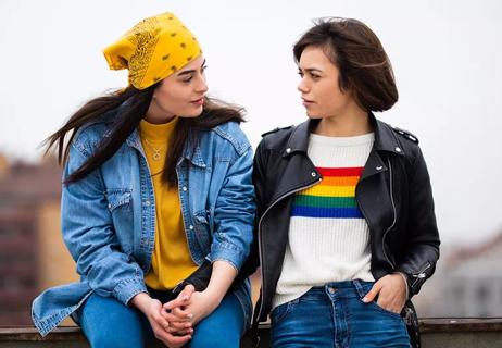 two woman talking rainbow sweater