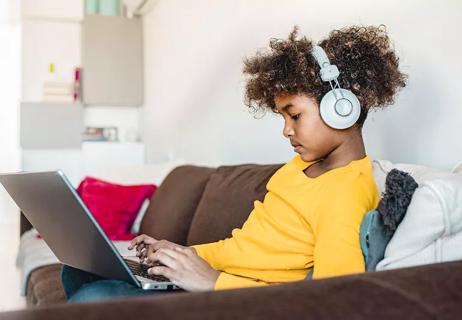 Child doing online schooling on a laptop.