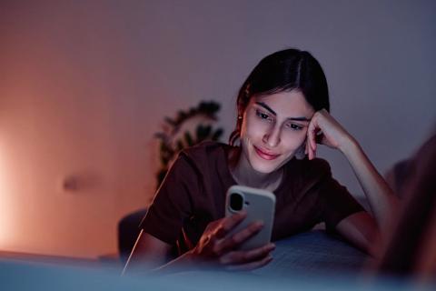 Person smiling while on their smartphone