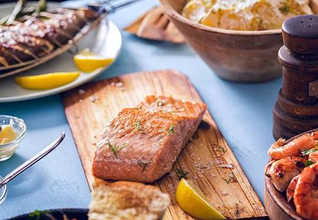 salmon filet and lemon slice on a plank board