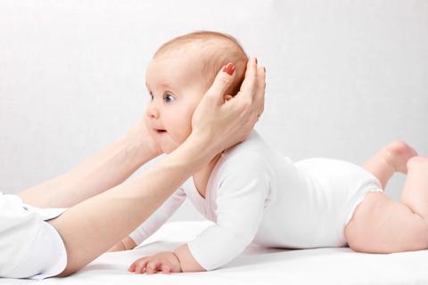 Baby with torticollis lies on tummy