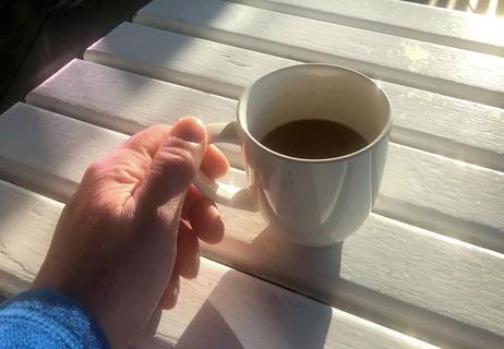 Man drinking coffee on deck in morning