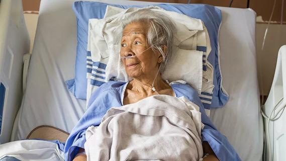 photo of intubated elderly woman in hospital bed