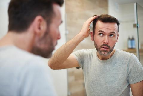 Person checking out their hair in the mirror