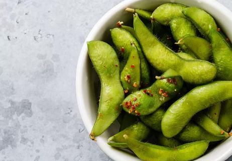 Cooked edamame in a white bowl