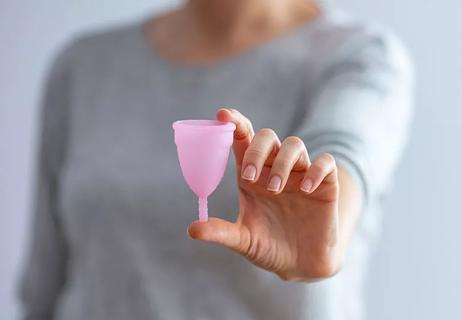 Woman holding a mentral cup in her hand.