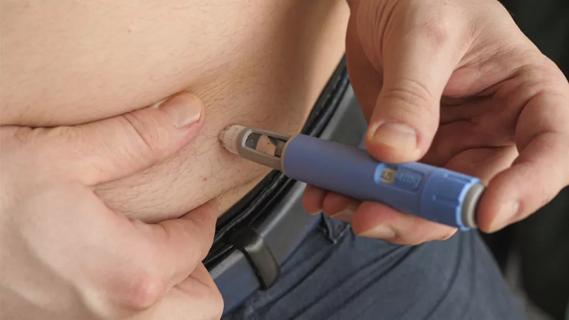 person injecting weight loss drug