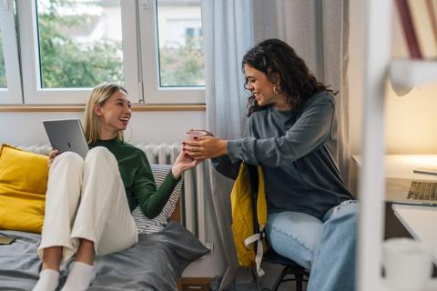 Two female college roommates in their dorm room