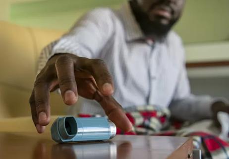 man reaching for inhaler