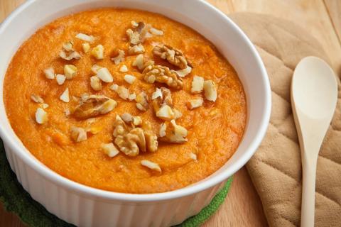 Ramekin of pumpkin pudding topped with walnuts