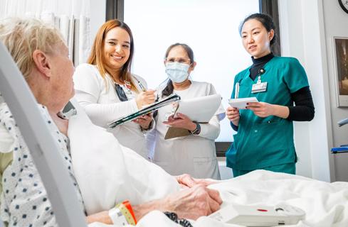 Nurses talking to patient at the bedside