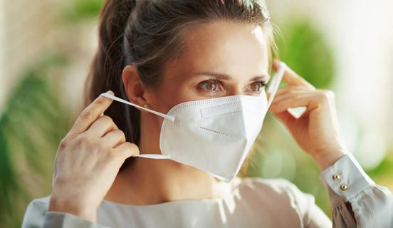 Woman putting on a disposable medical mask