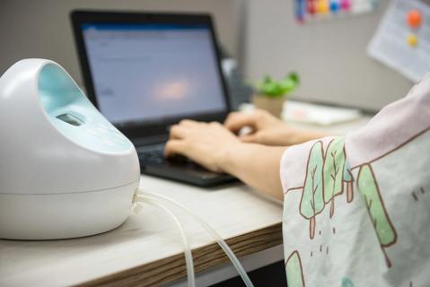 Female using breast pump machine while at work