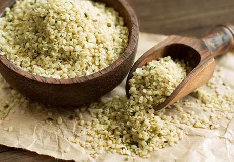 bowl and scoop of uncooked hemp seeds