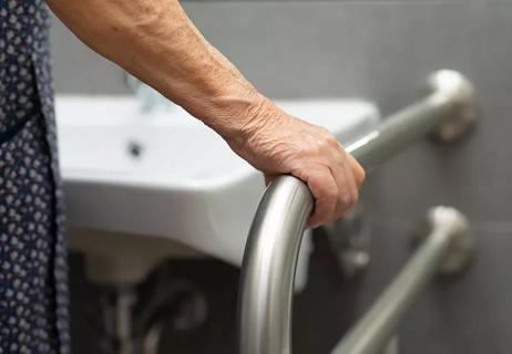 Person holding a bathroom grab bar for balance