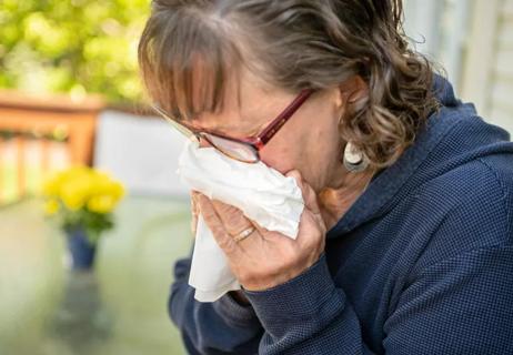 woman sneezing because of allergies